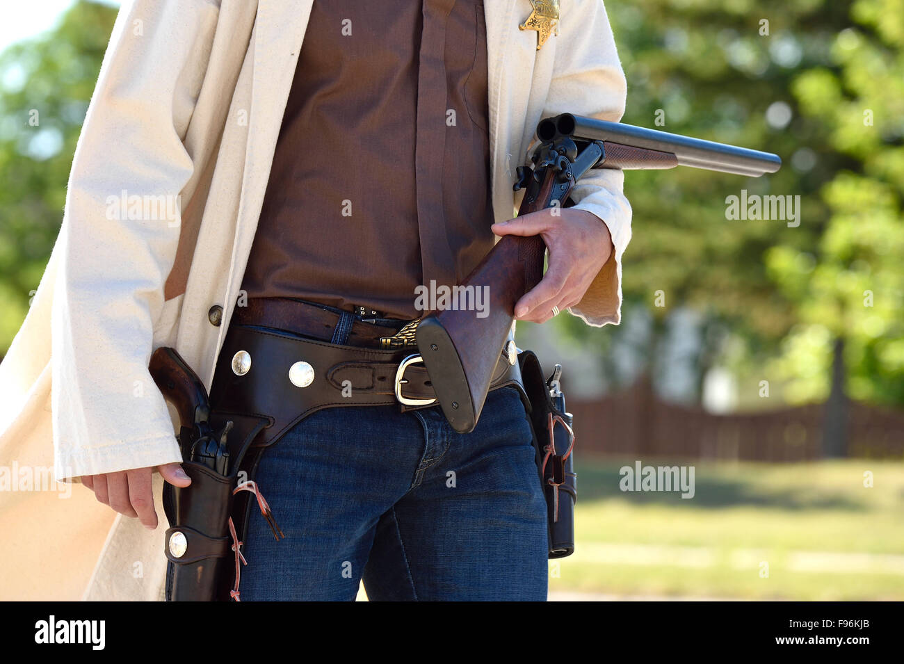 Eine Nahaufnahme Bild von einem bewaffneten Cowboy Durchfürung einer Schrotflinte und zwei Seitenarme in einer Parade in ländlichen Alberta, Kanada Stockfoto