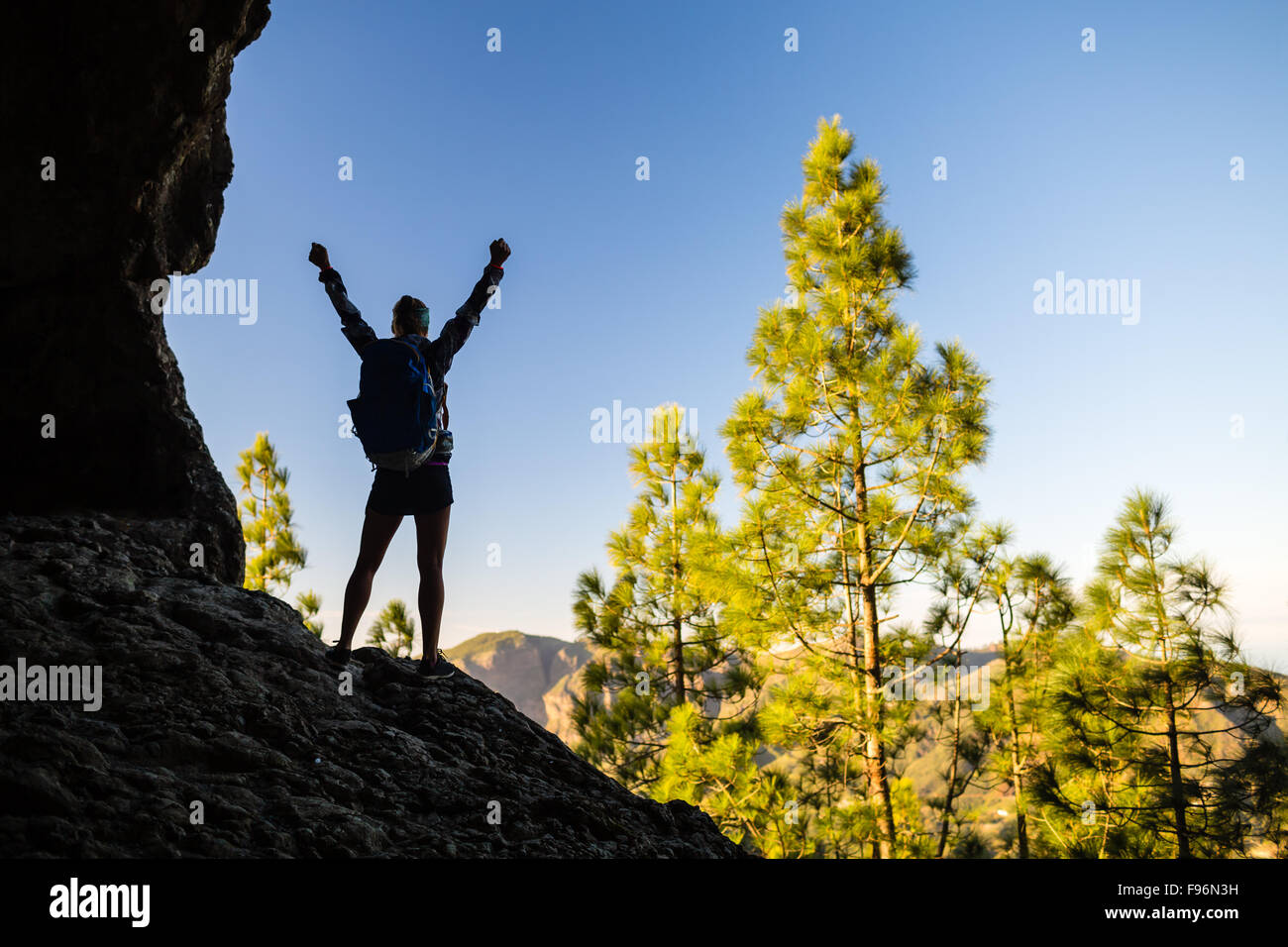 Frau erfolgreich Wandern Klettern Silhouette in Bergen, Motivation und Inspiration im wunderschönen Sonnenuntergang und das Meer. Weibliche Wanderer Stockfoto