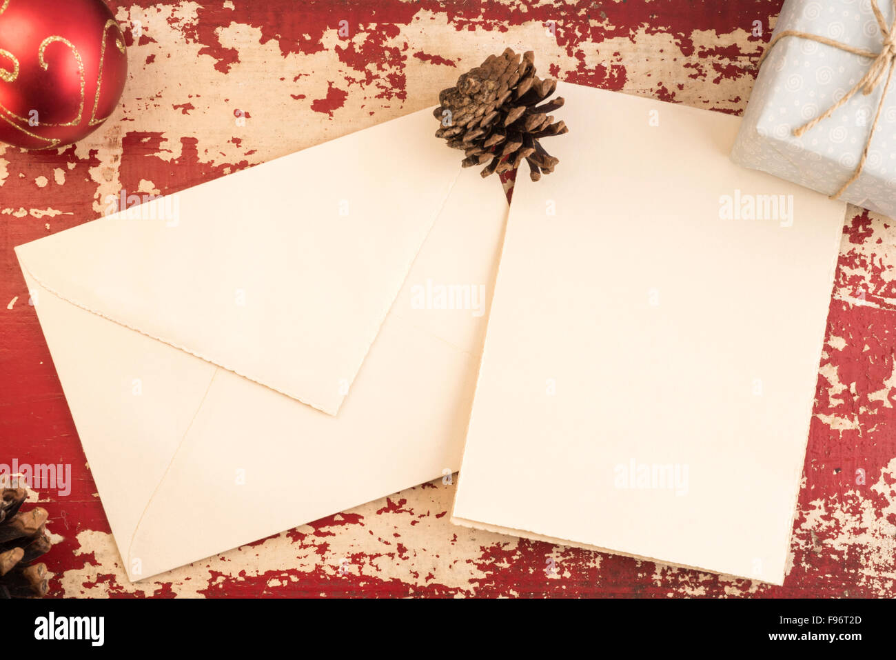 Weihnachten-Konzept, Draufsicht leeren Umschlag Grußkartenvorlage mit Kiefer Kegel und Urlaub Dekoration auf Vintage Grunge Holz Stockfoto