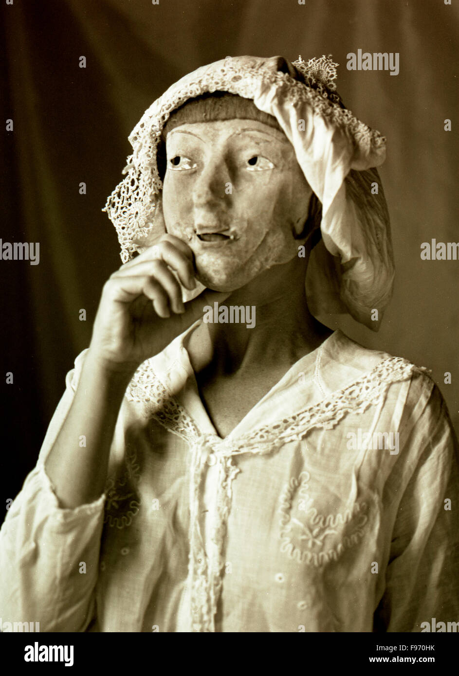 Frau in der Antike Kleidung hält eine Maske auf ihr Gesicht. Stockfoto