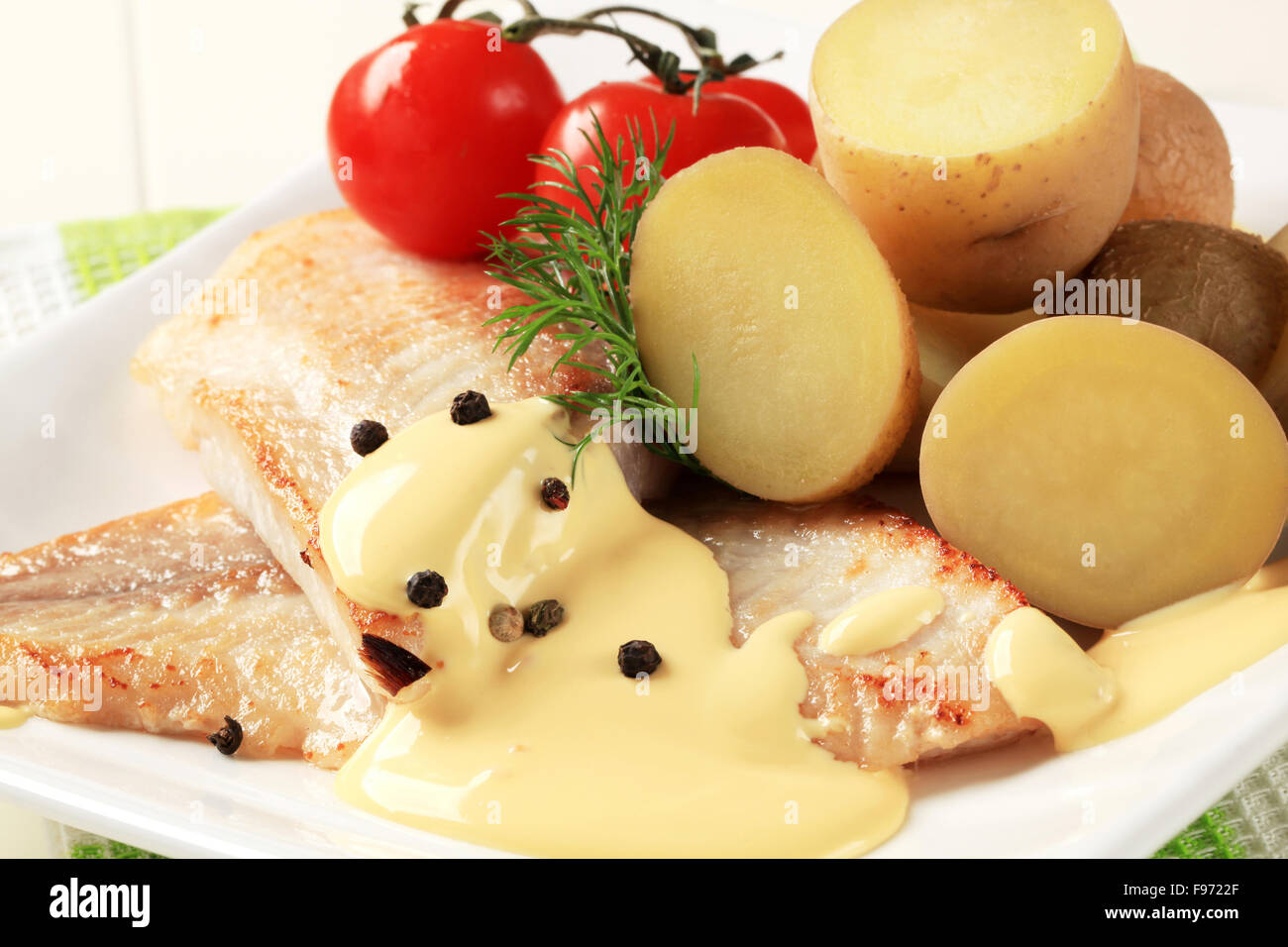 Weiße Fischfilets mit neuen Kartoffeln und Sauce Hollandaise Stockfoto