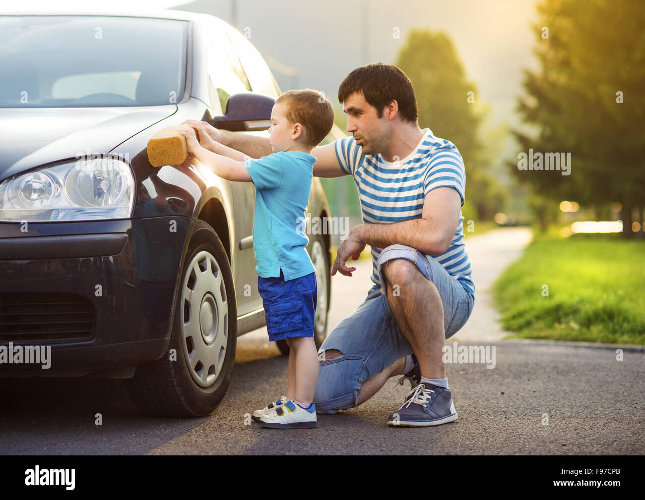 Junger Vater mit seinem kleinen Sohn Waschen Auto Stockfoto