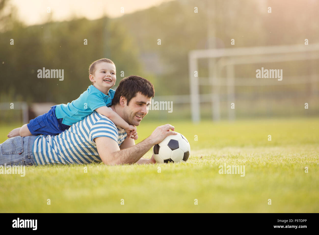 Junger Vater mit seinem kleinen Sohn Spaß am Fußballplatz Stockfoto