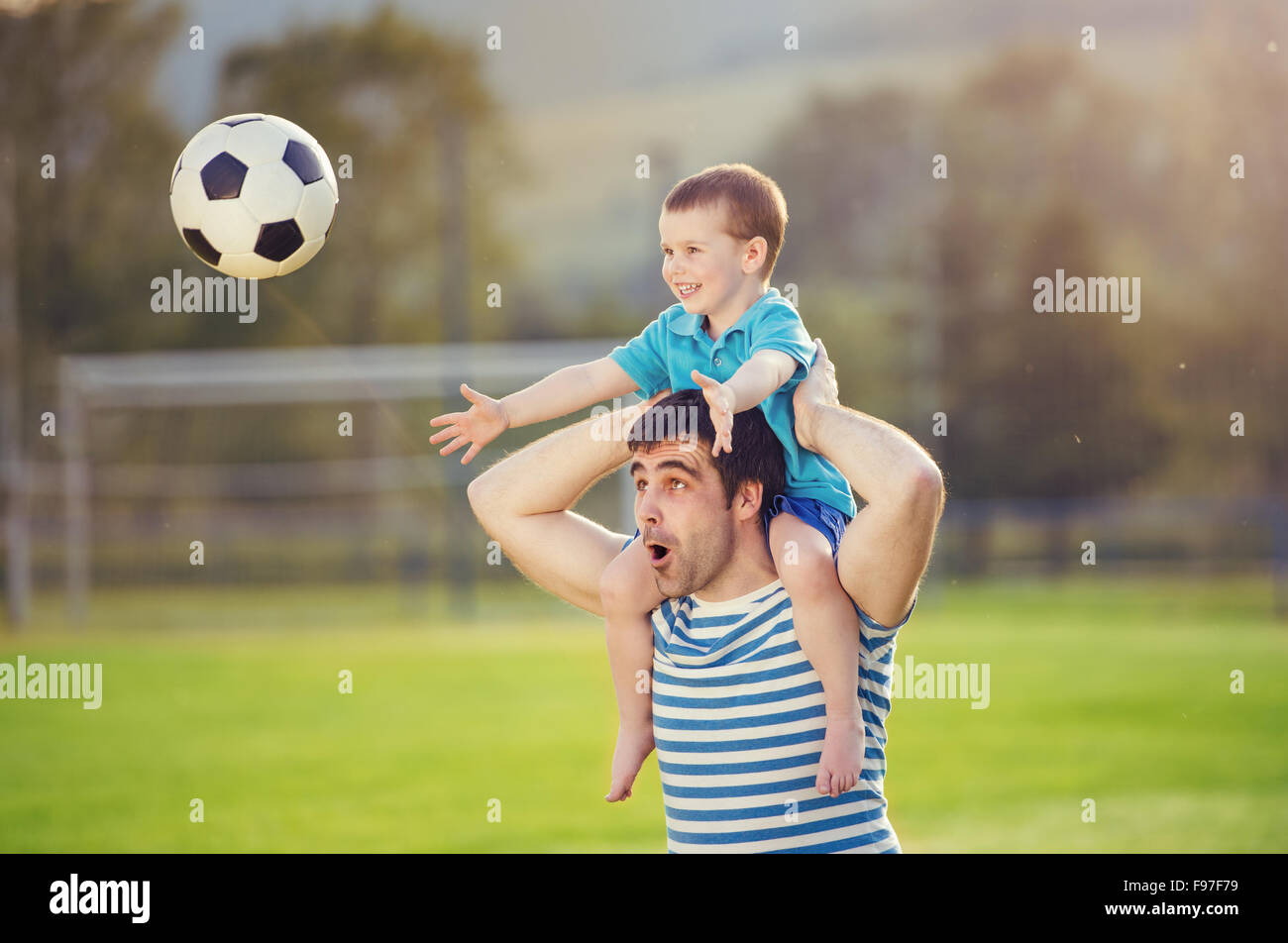 Junger Vater mit seinem kleinen Sohn Spaß am Fußballplatz Stockfoto