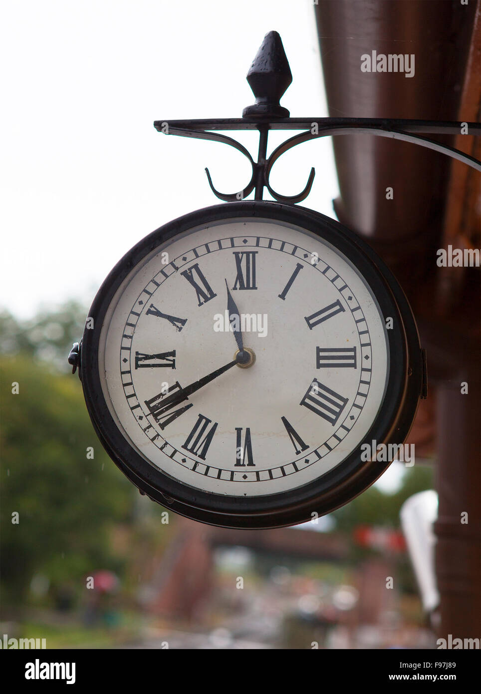 Klassische Vintage Uhr am alten Bahnhof mit Regen auf Zifferblatt Stockfoto