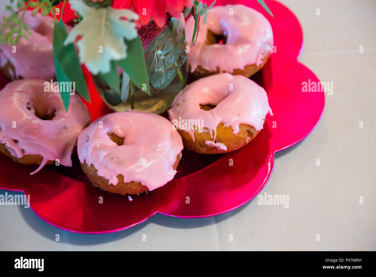 Details bei einer Hochzeitsfeier gehören rosa Dekor und Donuts. Stockfoto