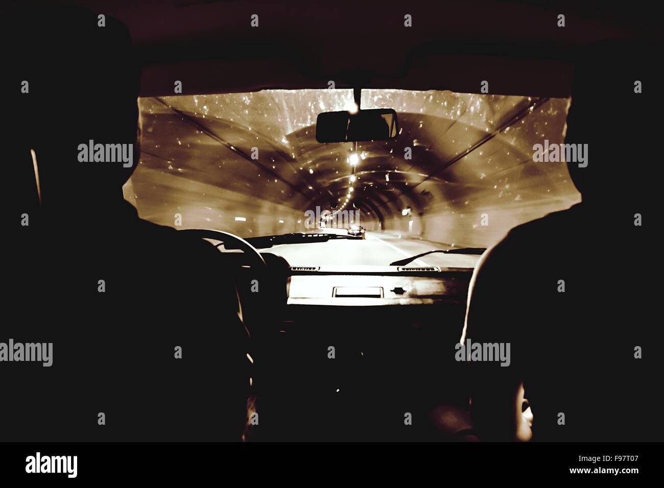 Silhouette Menschen fahren Auto In beleuchteten Tunnel Stockfoto