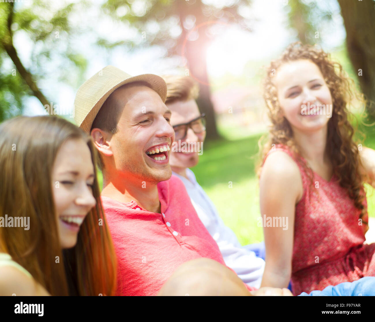 Gruppe von Jugendlichen, die Spaß im Park, sitzen auf dem Rasen Stockfoto