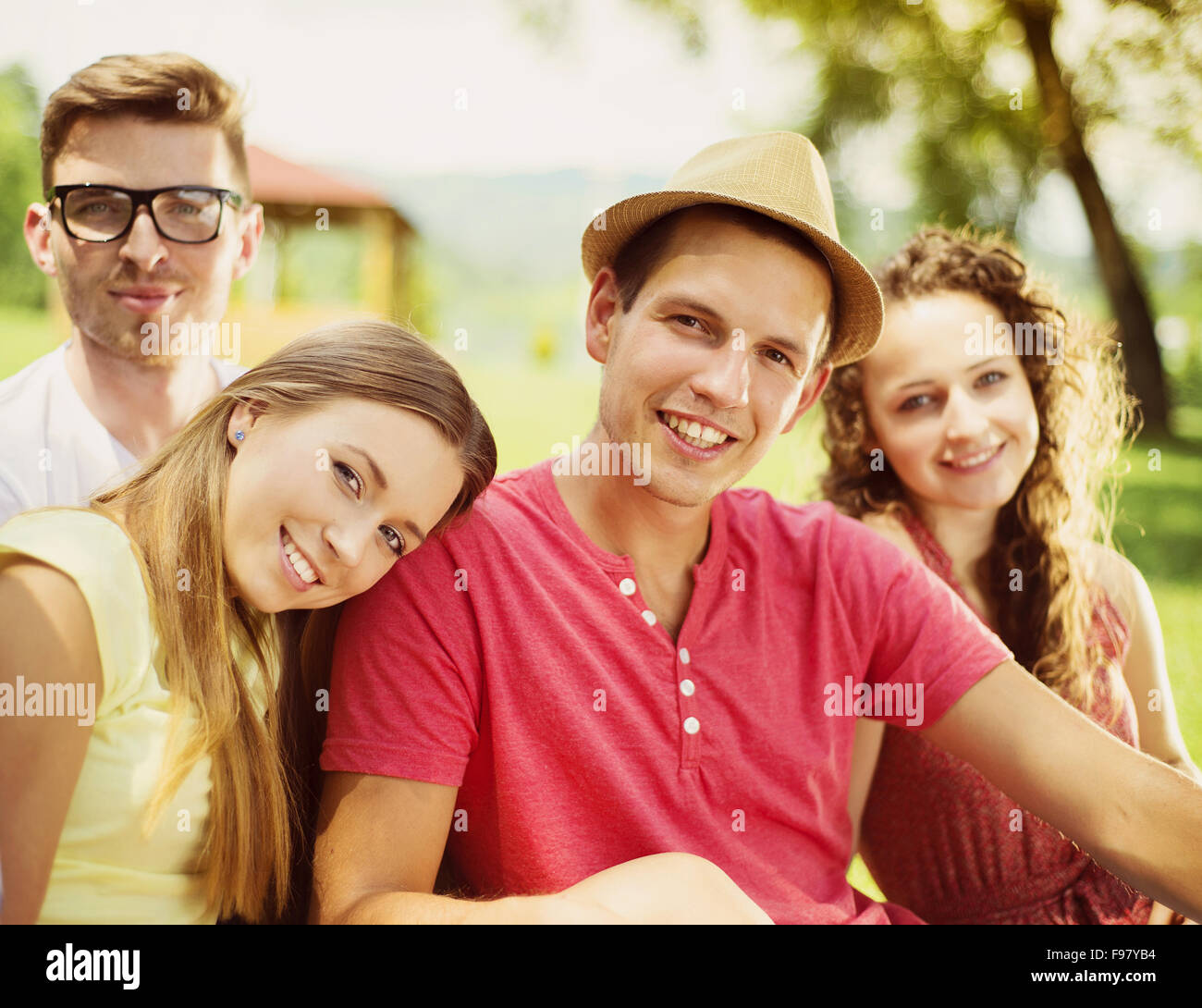 Gruppe von Jugendlichen, die Spaß im Park, sitzen auf dem Rasen Stockfoto