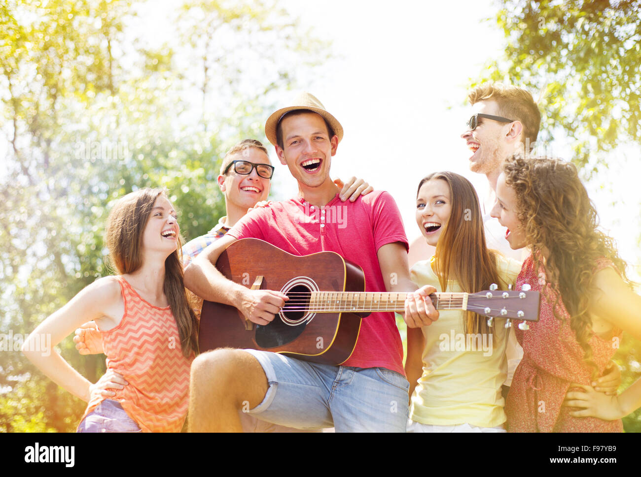 Gruppe der happy Friends mit Gitarre Spaß im freien Stockfoto