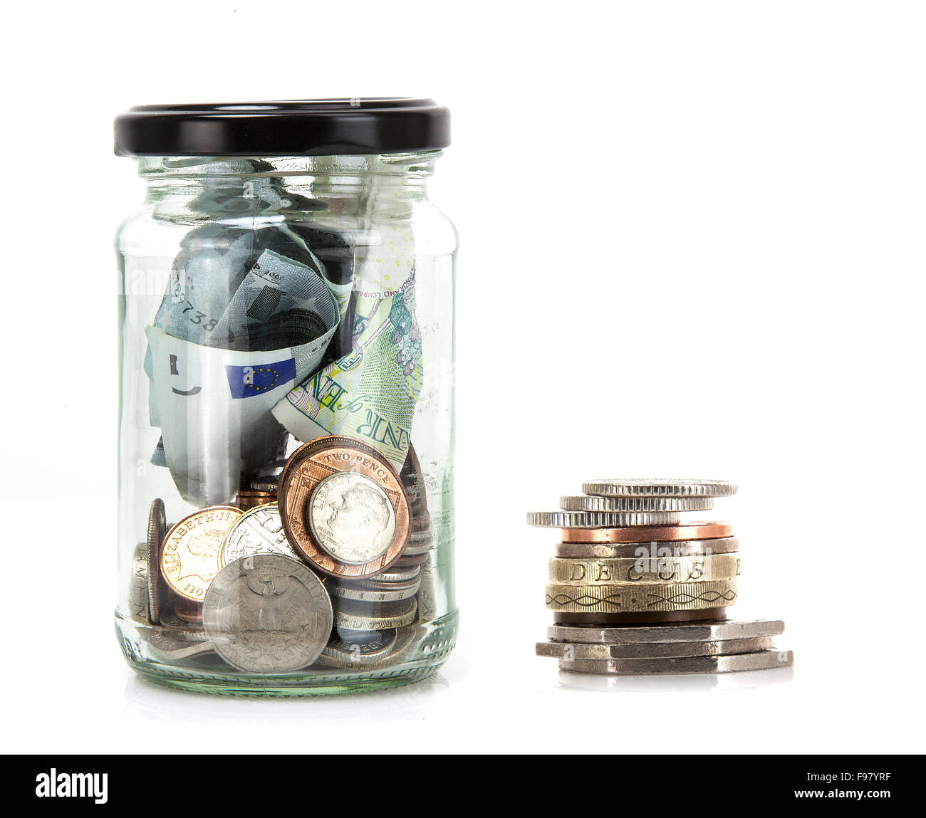 Glas mit Münzen und Banknoten aus der ganzen Welt auf einem weißen Hintergrund - Einsparungen Konzept Stockfoto