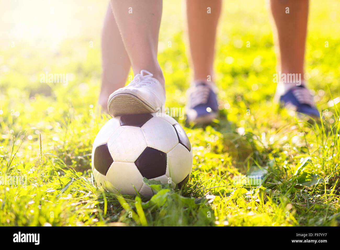 Nahaufnahme der Füße und Fußball Ball auf grünem Rasen Stockfoto