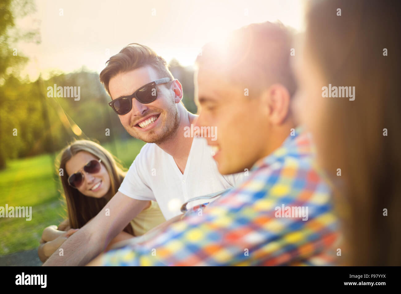 Gruppe von Jugendlichen, die Spaß im Park, sitzen auf dem Rasen Stockfoto