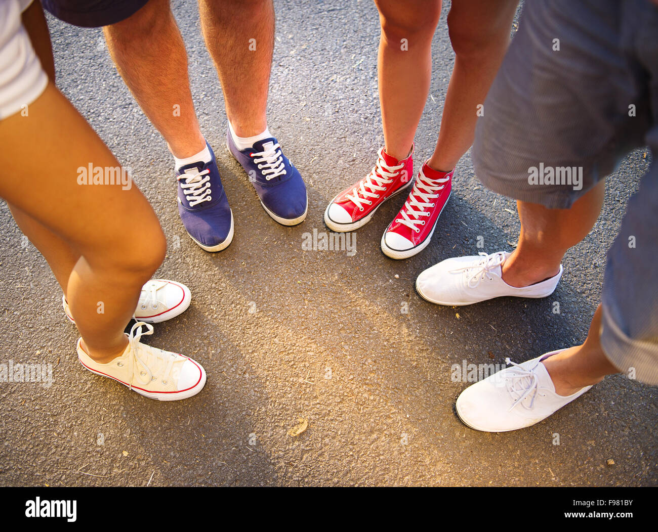 Beine und Sneakers von Teenager-Jungen und Mädchen stehen auf dem Bürgersteig Stockfoto