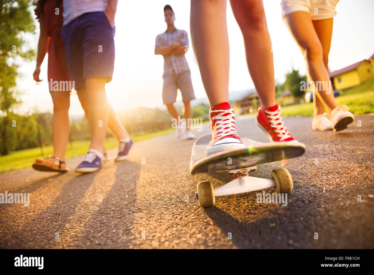 Nahaufnahme der Beine und Turnschuhe von Jugendlichen auf skateboard Stockfoto