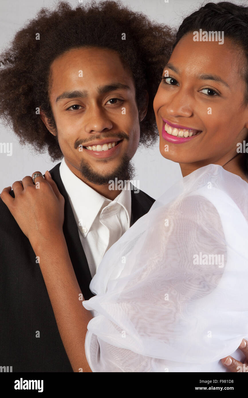 Romantische Schwarz Paar, sie in einem Brautkleid und berühren Stockfoto