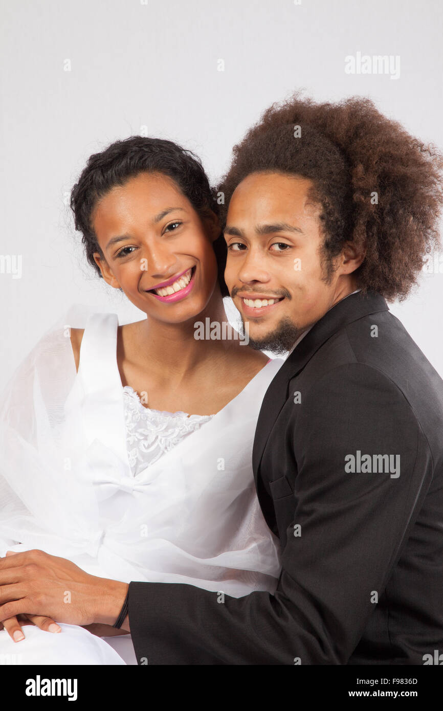 Romantische Schwarz Paar, sie in einem Brautkleid und berühren Stockfoto