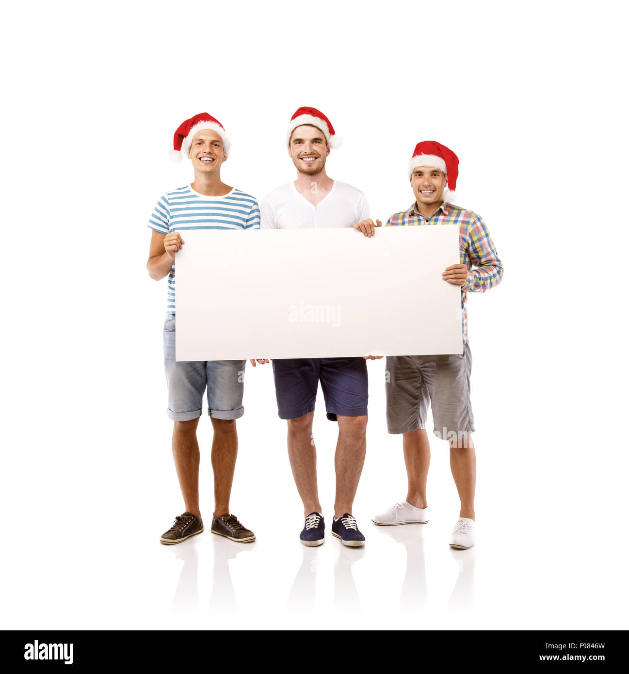 Drei junge Männer in Santa Hüte mit Textfreiraum, isoliert auf weißem Hintergrund Stockfoto