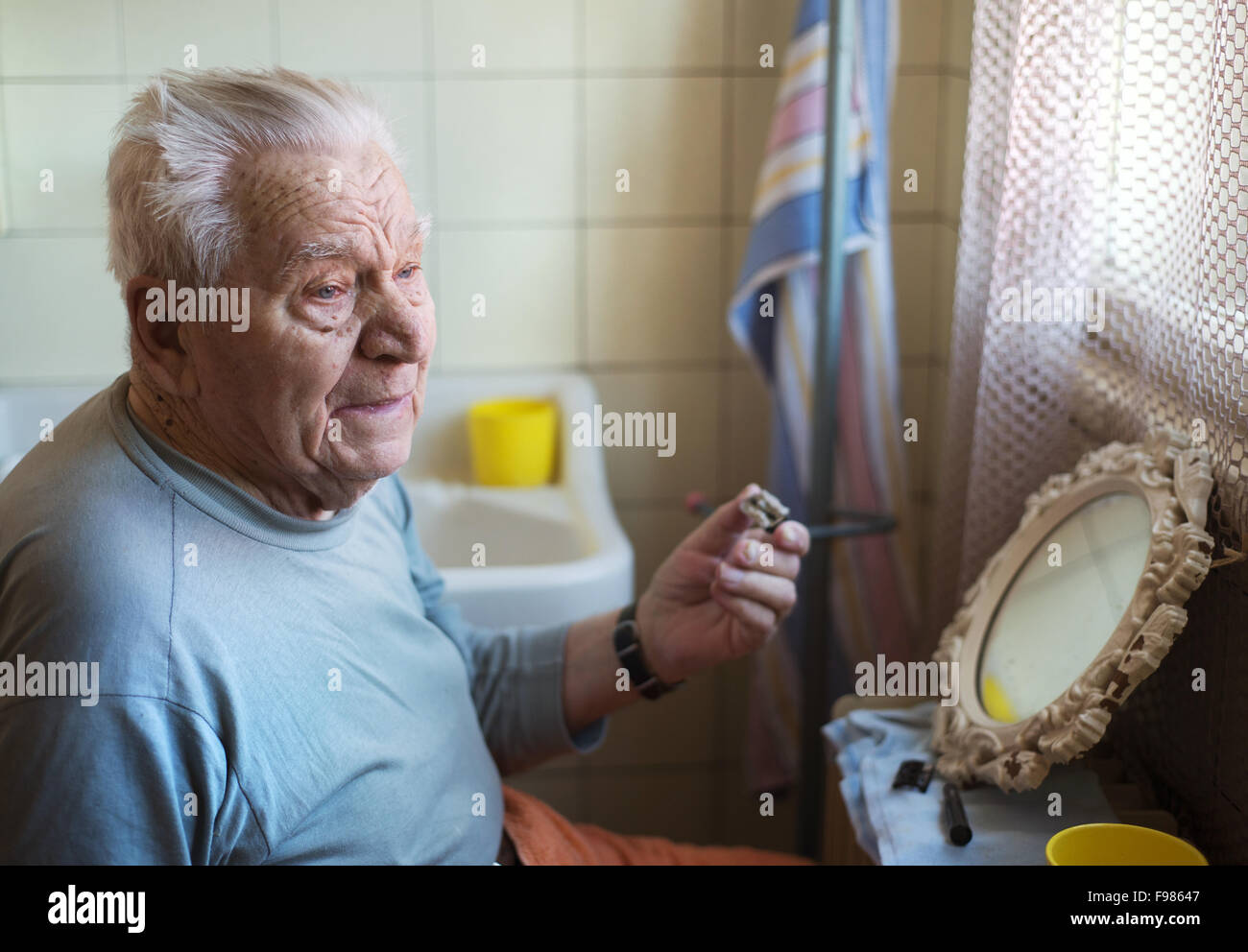 Senior woman rasieren Bart im Badezimmer vor dem Spiegel Stockfoto
