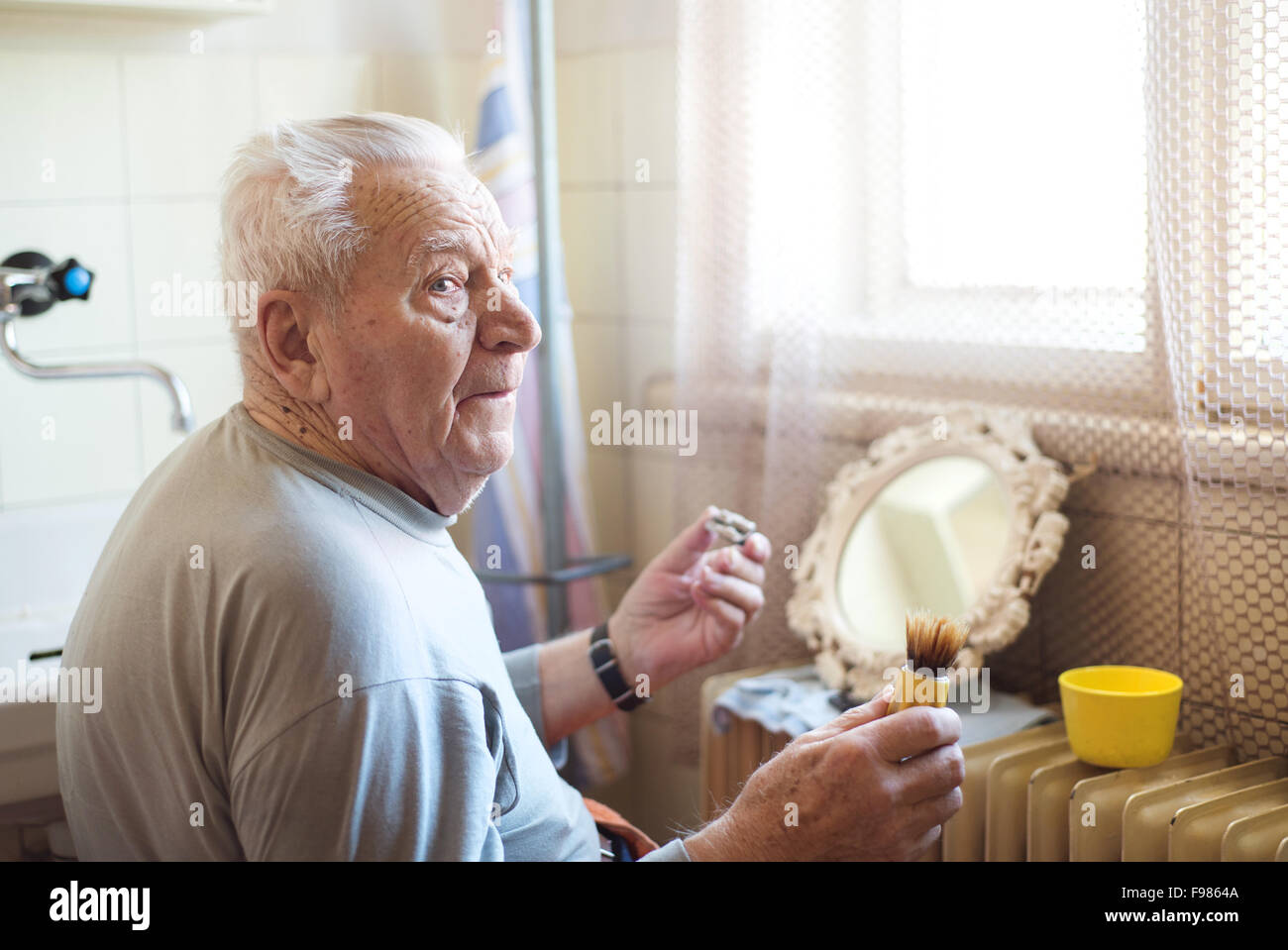 Senior woman rasieren Bart im Badezimmer vor dem Spiegel Stockfoto