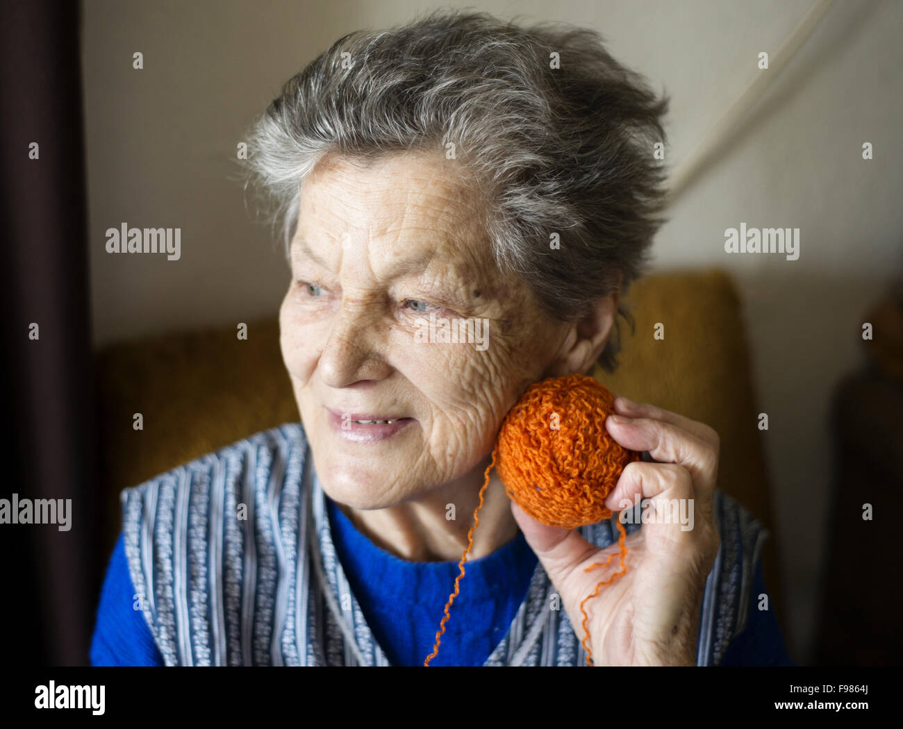 Porträt von senior Frau im Sessel sitzen und stricken zu Hause Stockfoto