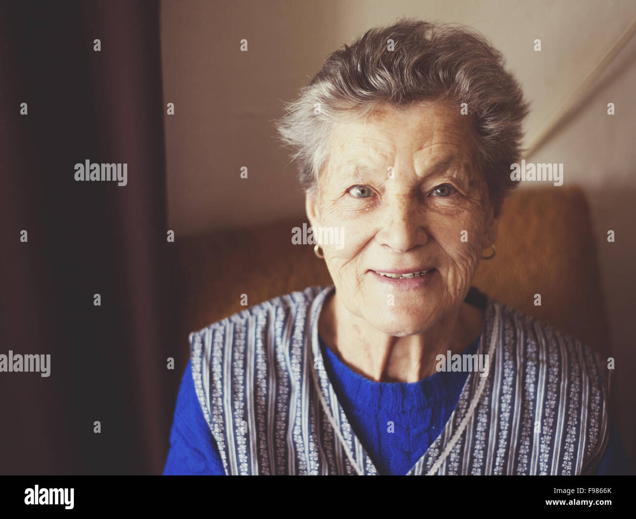 Porträt von senior Frau im Sessel zu Hause Stockfoto