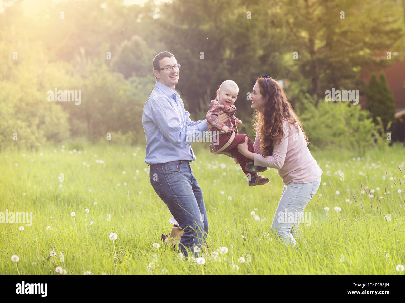 Glückliche Familie mit Sohn auf der Wiese spielen Stockfoto