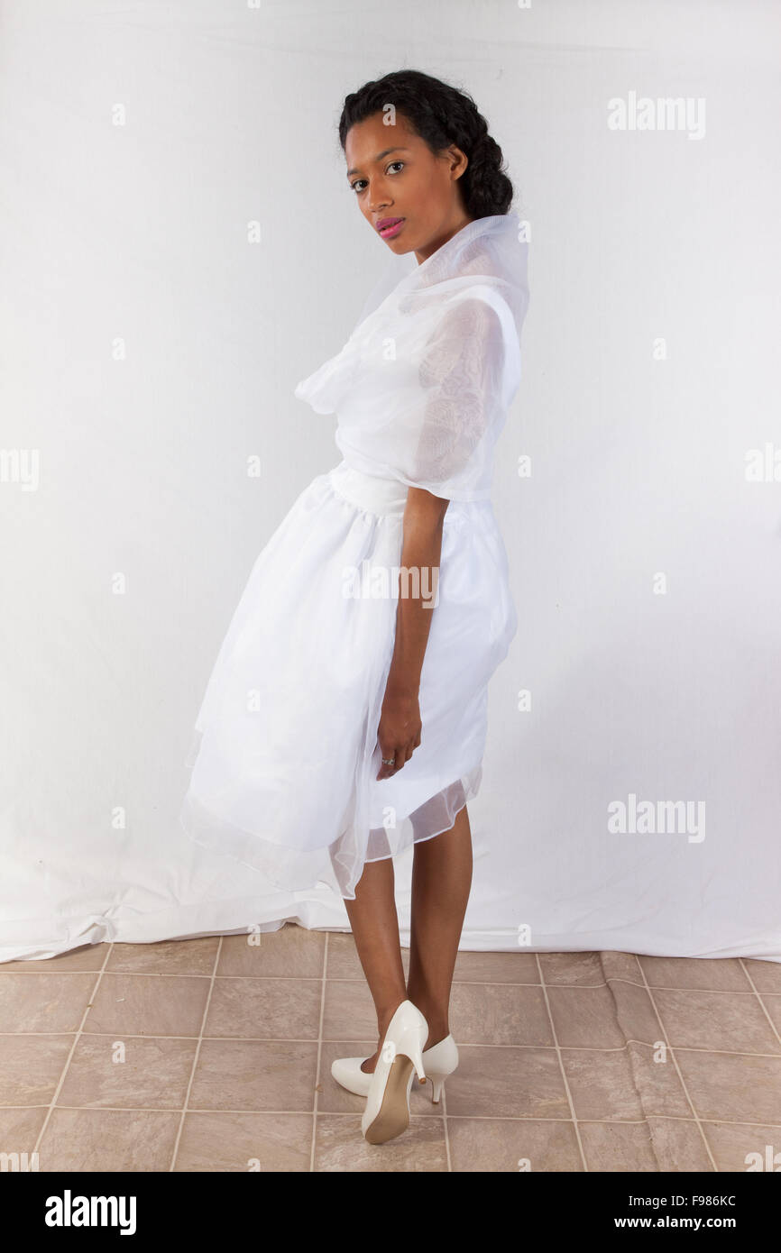 Hübsche schwarze Frau, die in einer weißen Hochzeit Kleid, nachdenklich Stockfoto