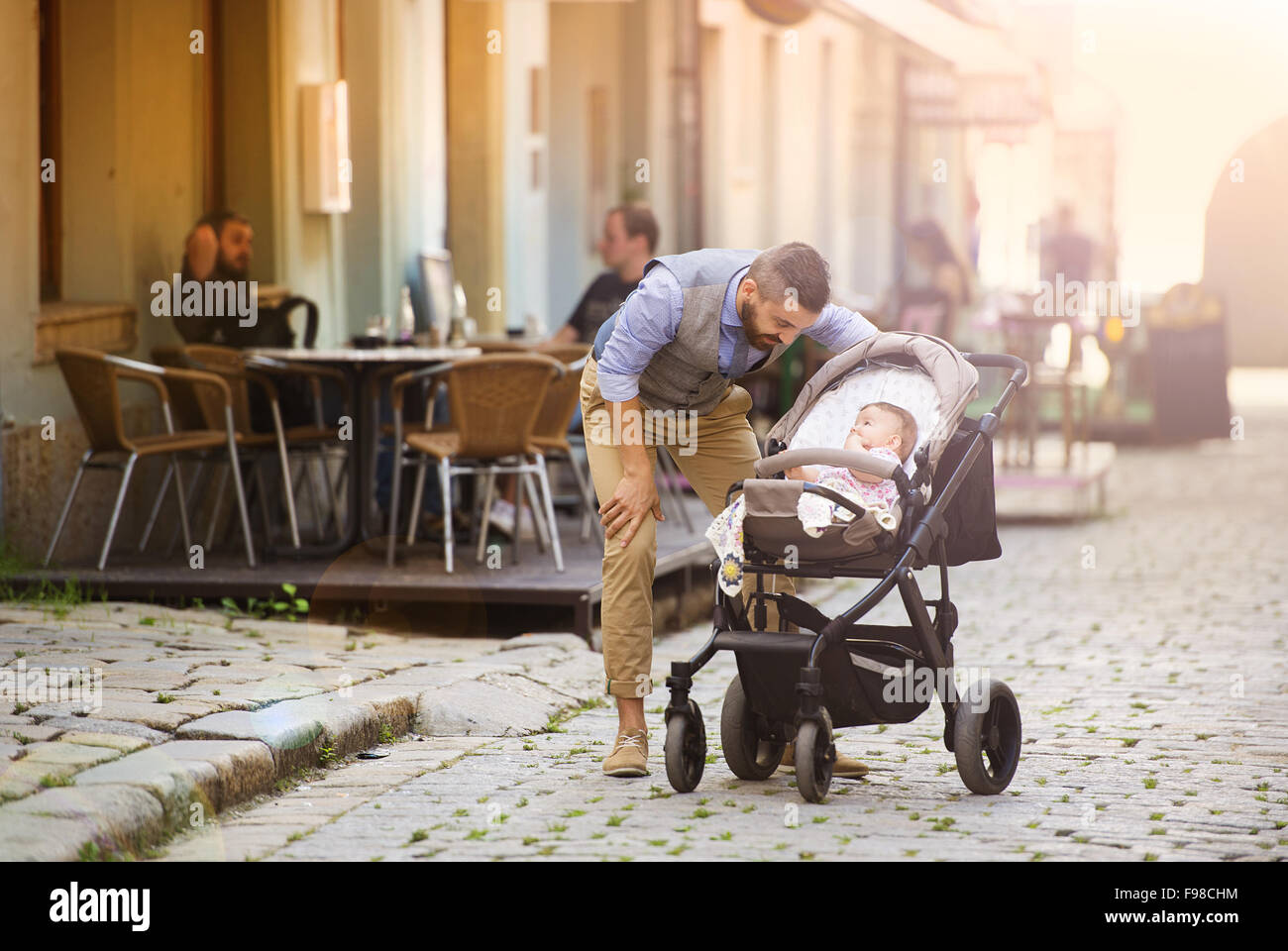 Hübsche Hipster modernen Geschäftsmann mit Bart mit Baby im Kinderwagen in der Stadt zu Fuß Stockfoto