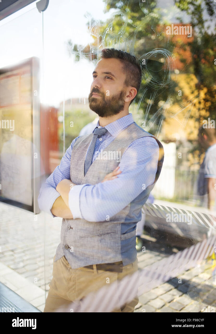 Der moderne Mensch gut aussehend Hipster Bus an der Bushaltestelle warten Stockfoto
