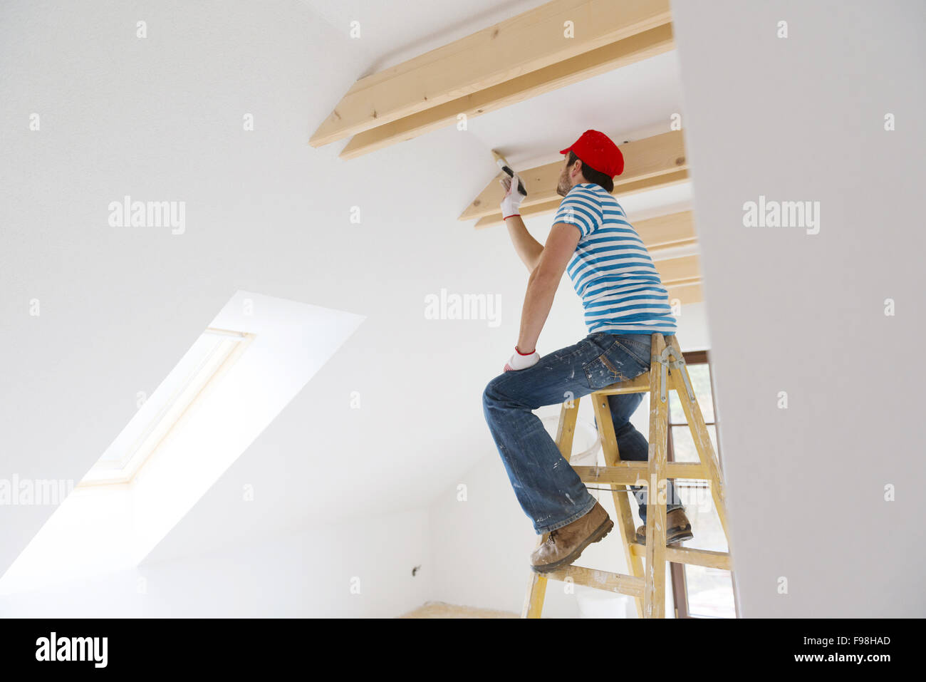 Glücklich lächelnden Mann Gemälde die Wände des neuen Heims mit Pinsel Stockfoto