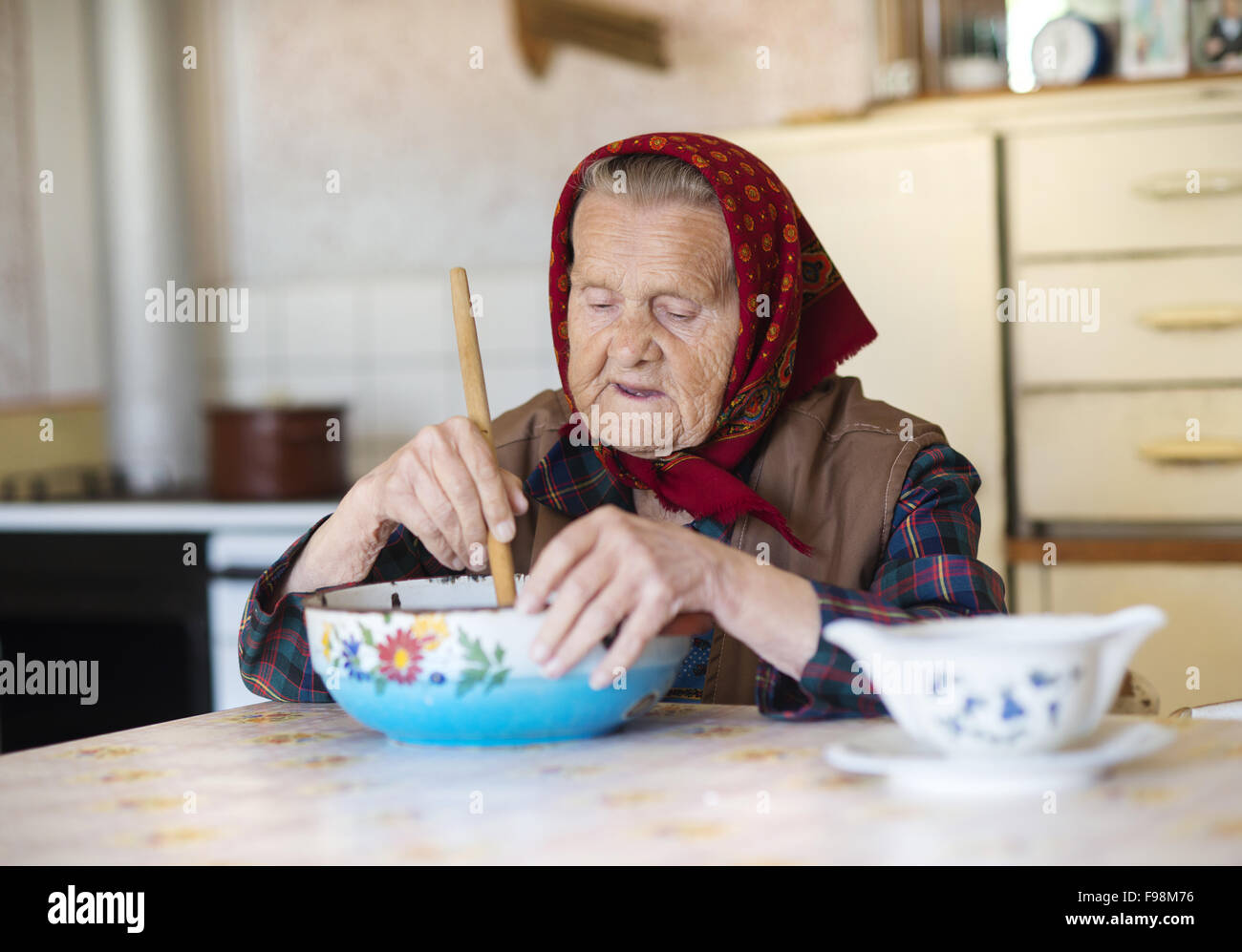 Sehr alte Frau, die Zubereitung von Speisen in ihrer alten Heimat Stil Küche Stockfoto