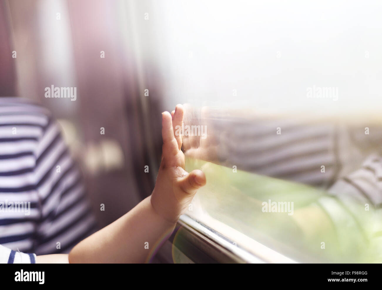 Junge in Retro-Zug unterwegs. Er berührt das Fenster. Stockfoto