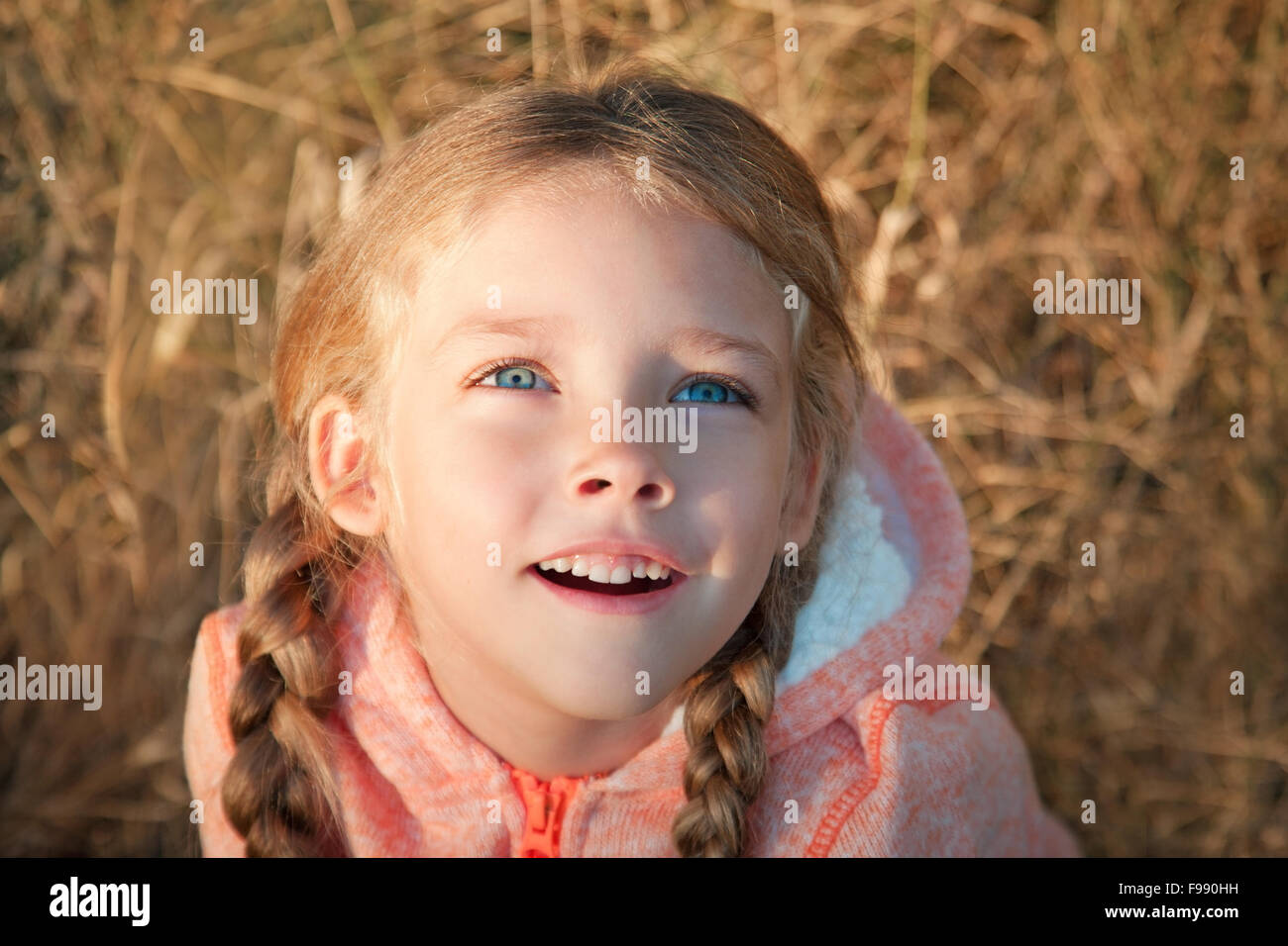 Porträt von einem kleinen Mädchen mit blauen Augen und Zöpfen Stockfoto