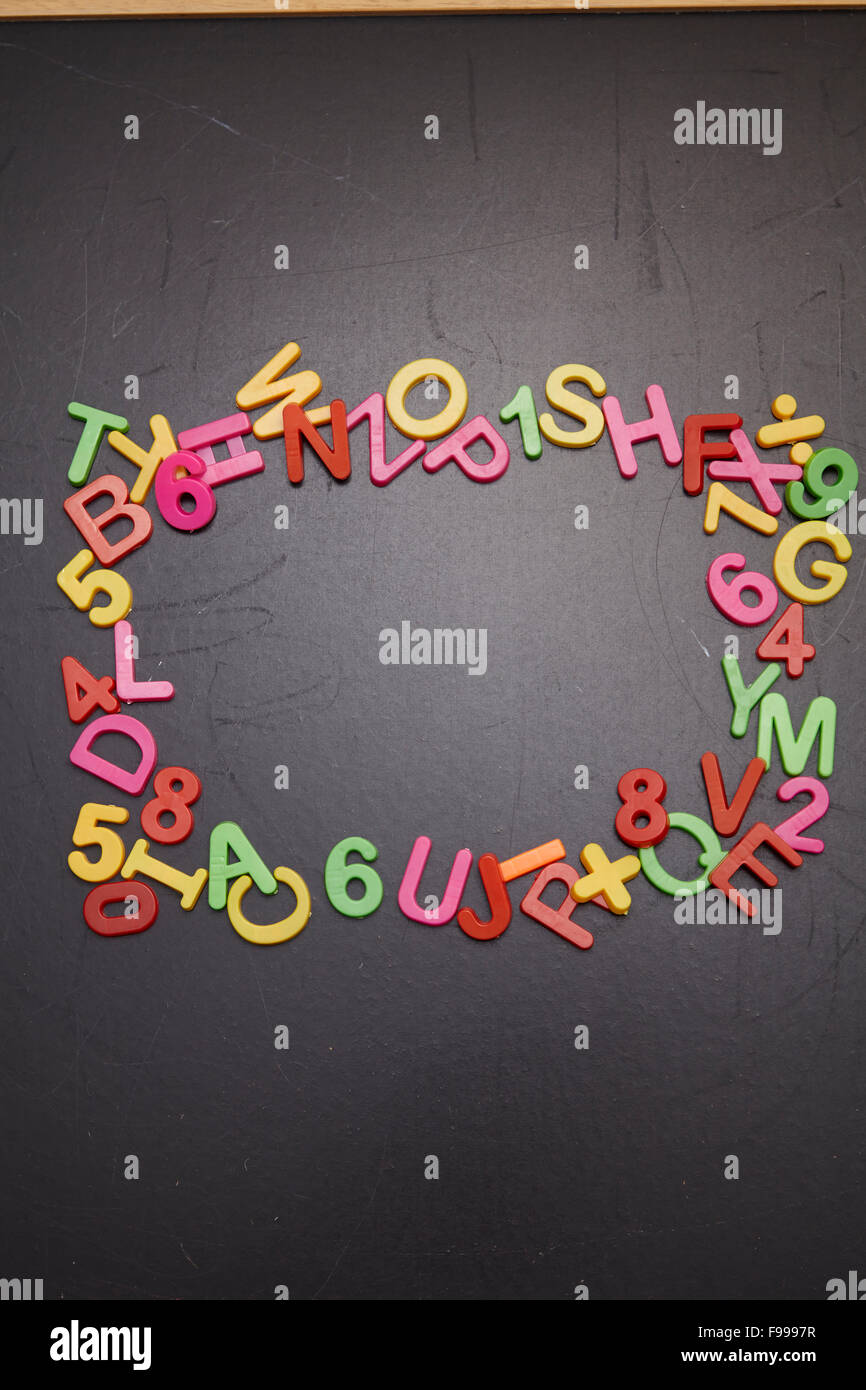 Rahmen aus Kunststoff bunten Buchstaben auf Tafel Stockfoto
