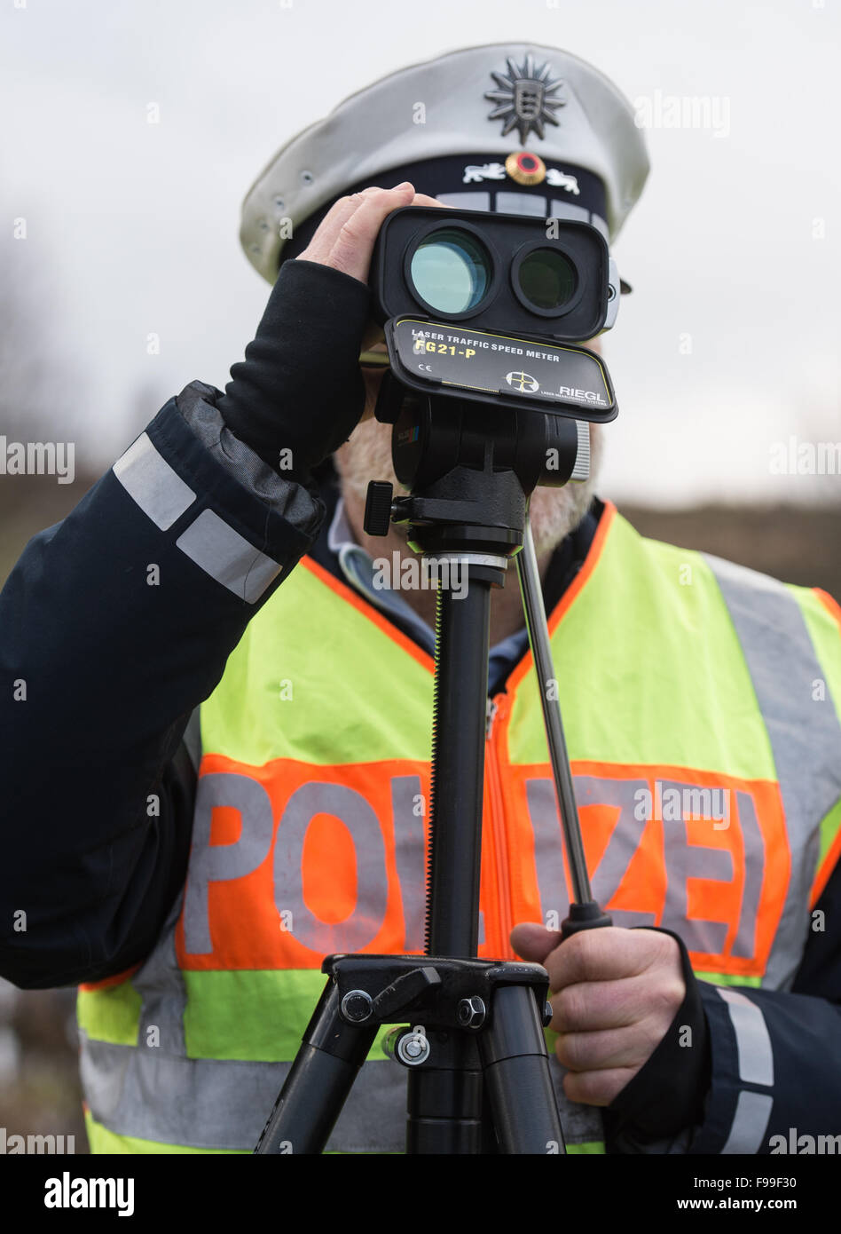 Gottmadingen, Deutschland. 9. Dezember 2015. Ein Polizist prüft die  Geschwindigkeit von Fahrzeugen mit einem Lasergerät auf der Autobahn A81  Autobahn in der Nähe von Gottmadingen, Deutschland, 9. Dezember 2015.  Illegale Rennen häufig