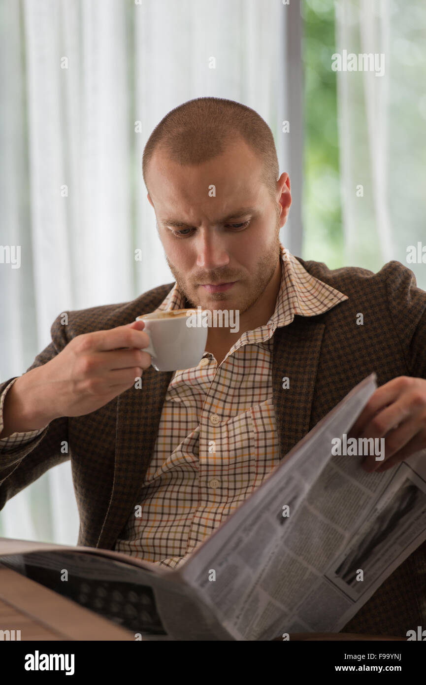 Nachdenklich Geschäftsmann im Café eine Zeitung lesen Stockfoto
