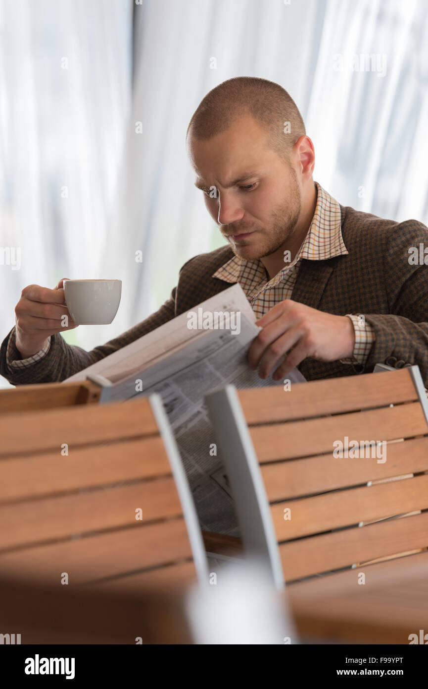 Nachdenklich Geschäftsmann im Café eine Zeitung lesen Stockfoto