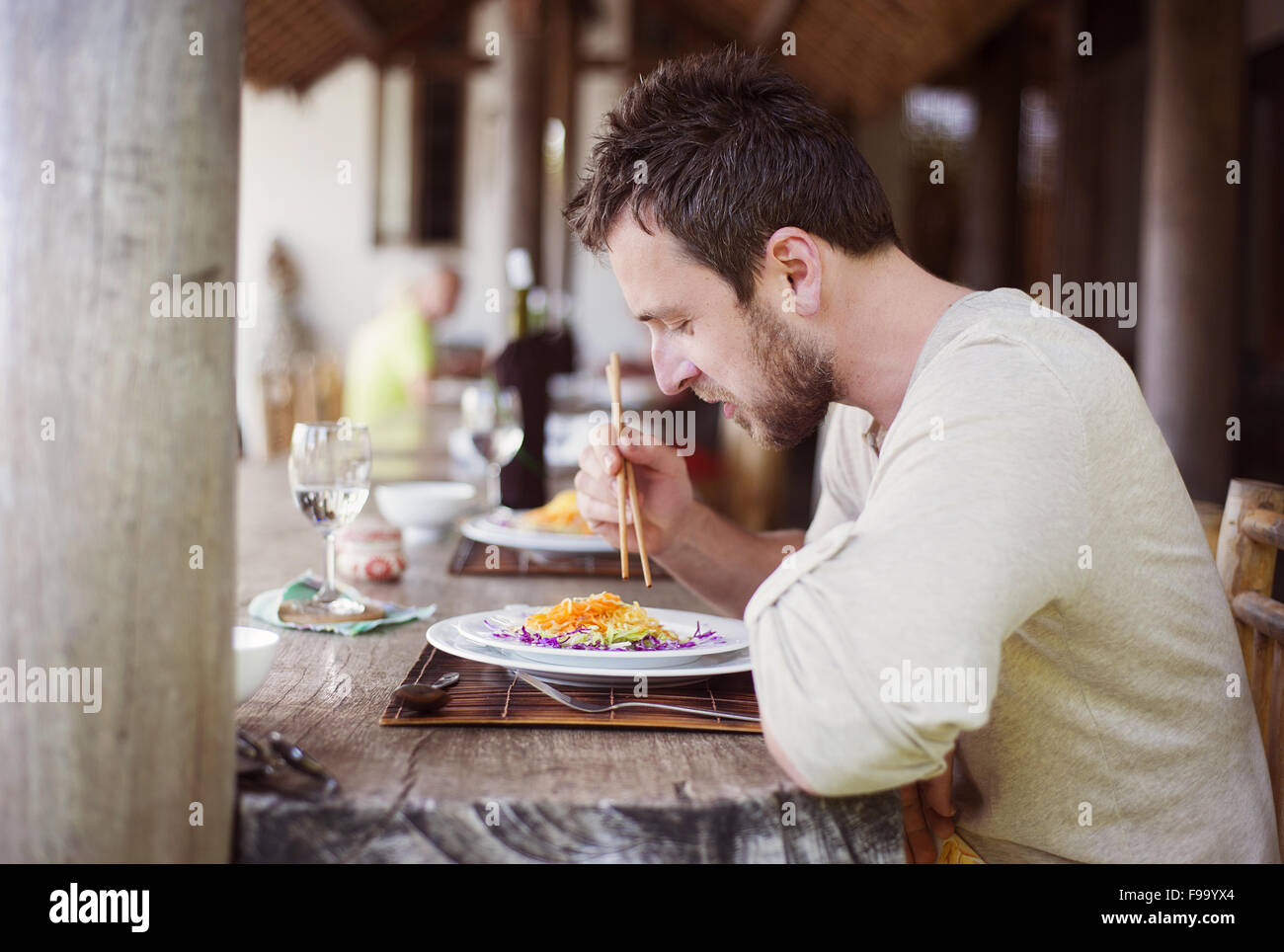 Mann, genießen Sie eine Mahlzeit mit Stäbchen in vietnamesischen restaurant Stockfoto