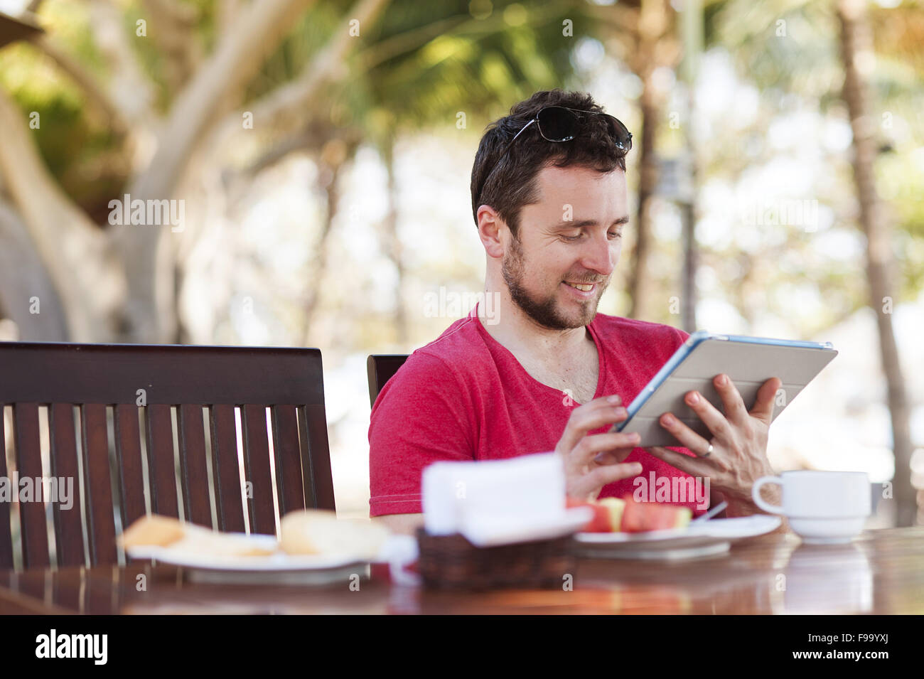 Hübscher Jüngling, entspannend und mit digital-Tablette Stockfoto