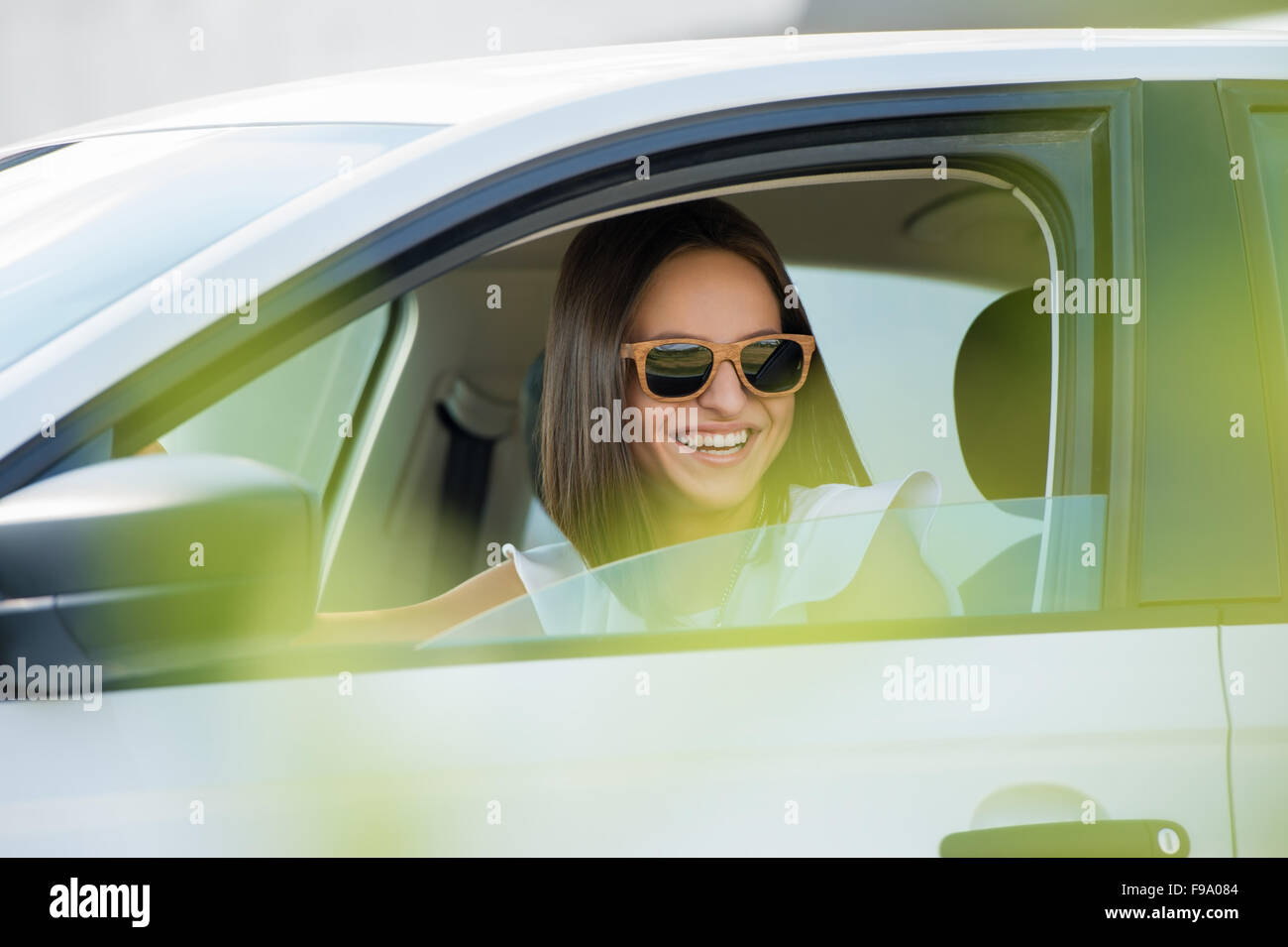 Mädchen mit Sonnenbrille fahren weißes Auto Stockfoto