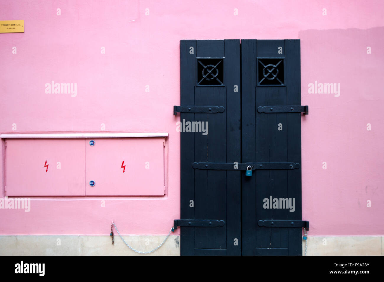 Eine rosa Wand mit einem Vorhängeschloss schwarzen Tor Stockfoto