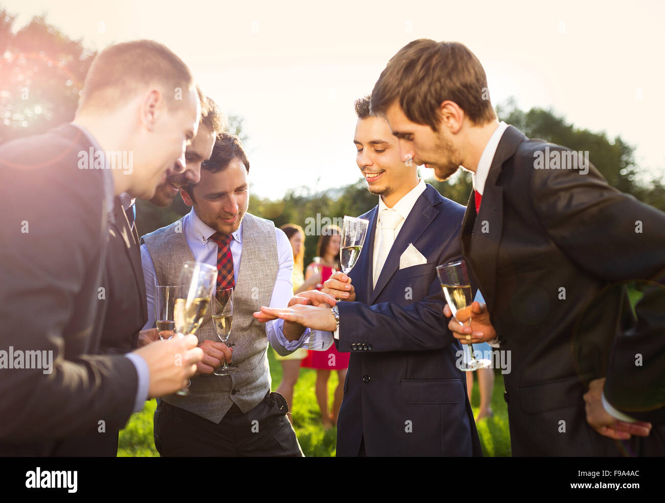 Bräutigam mit vier glückliche Trauzeugen bei der Hochzeitsfeier außerhalb Toasten Stockfoto