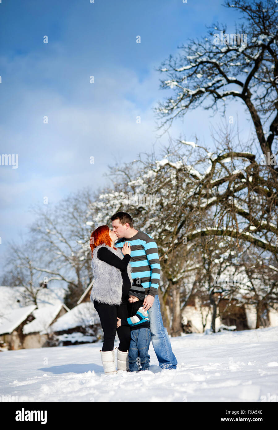 Glückliche Eltern mit Kind Spaß draußen im Schnee Stockfoto