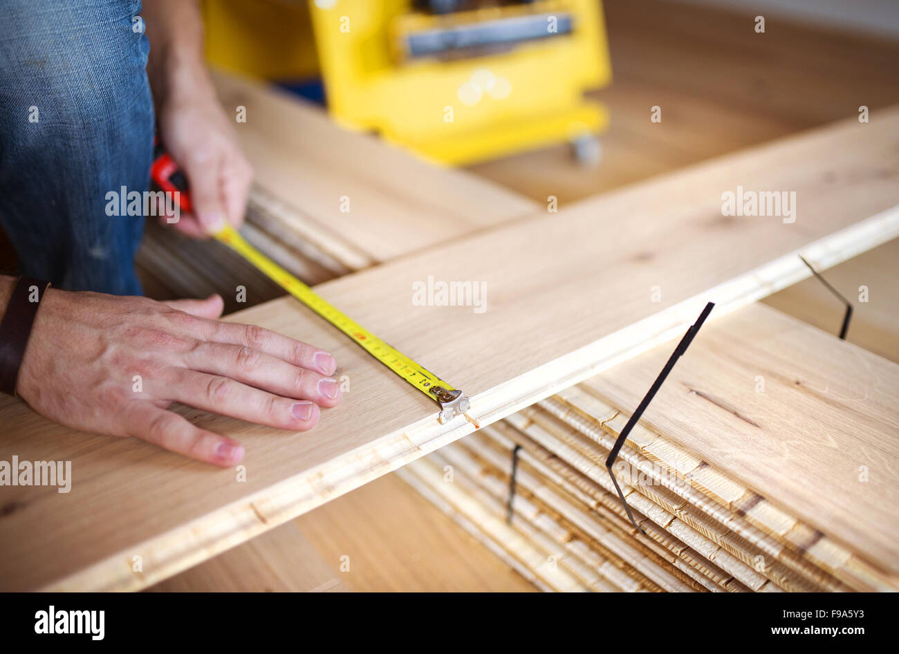 Nahaufnahme von Handymans Händen messen Holzboden Stockfoto