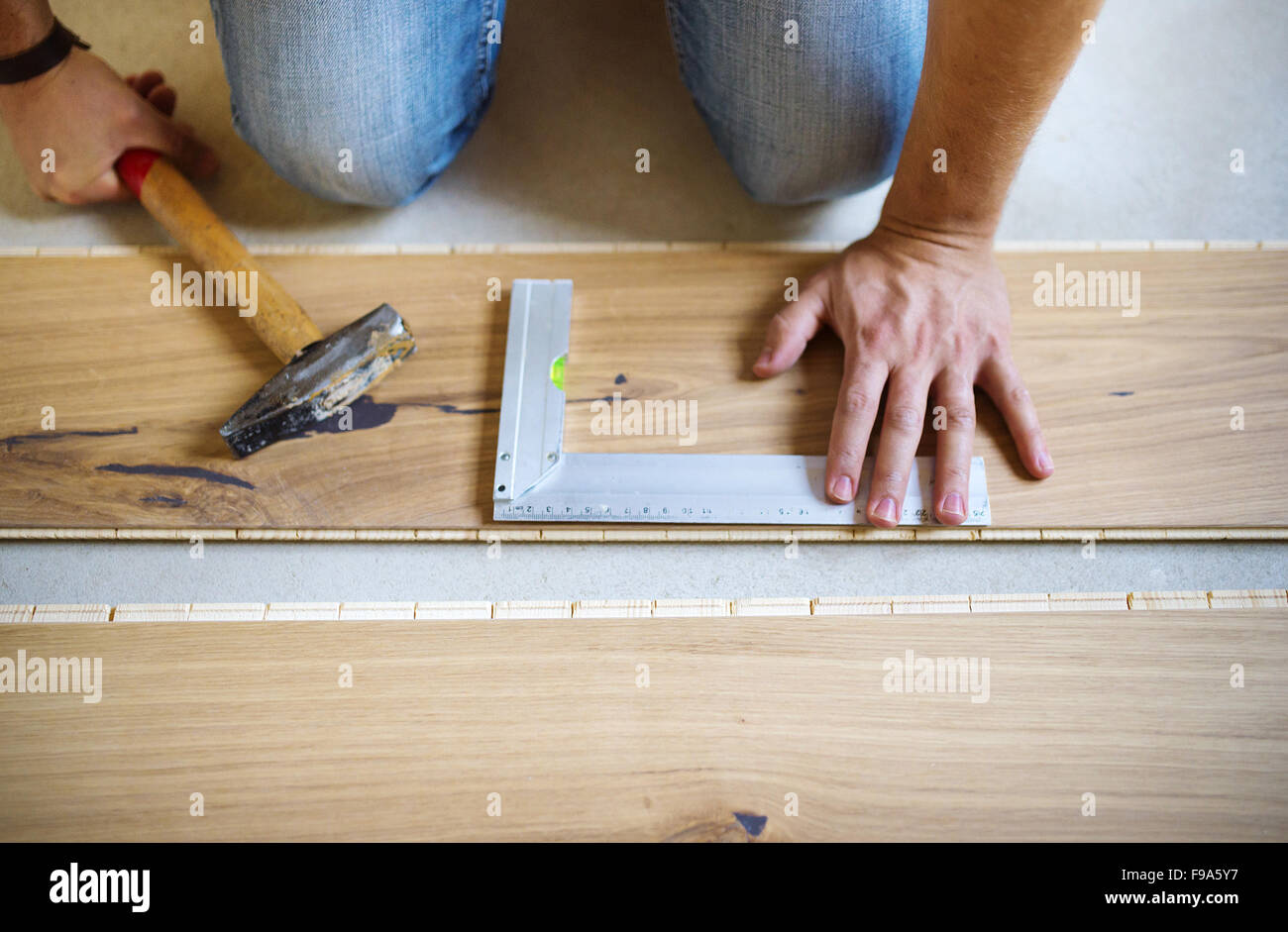 Nahaufnahme von Handymans Händen messen Holzboden Stockfoto