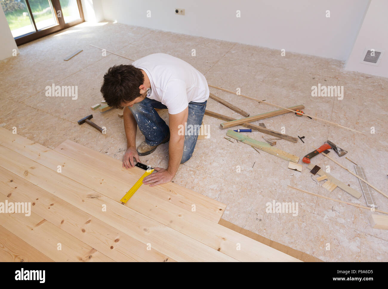 Mann, die Messung der Holzboden im neuen Haus Stockfoto