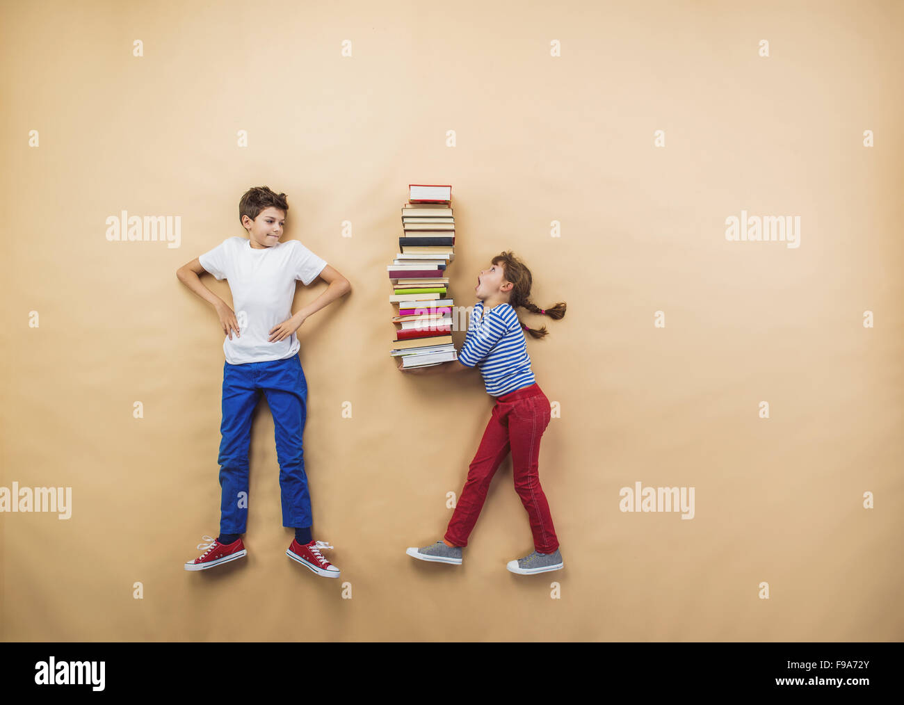 Glückliche Kinder, die spielen mit Gruppe von Büchern im studio Stockfoto