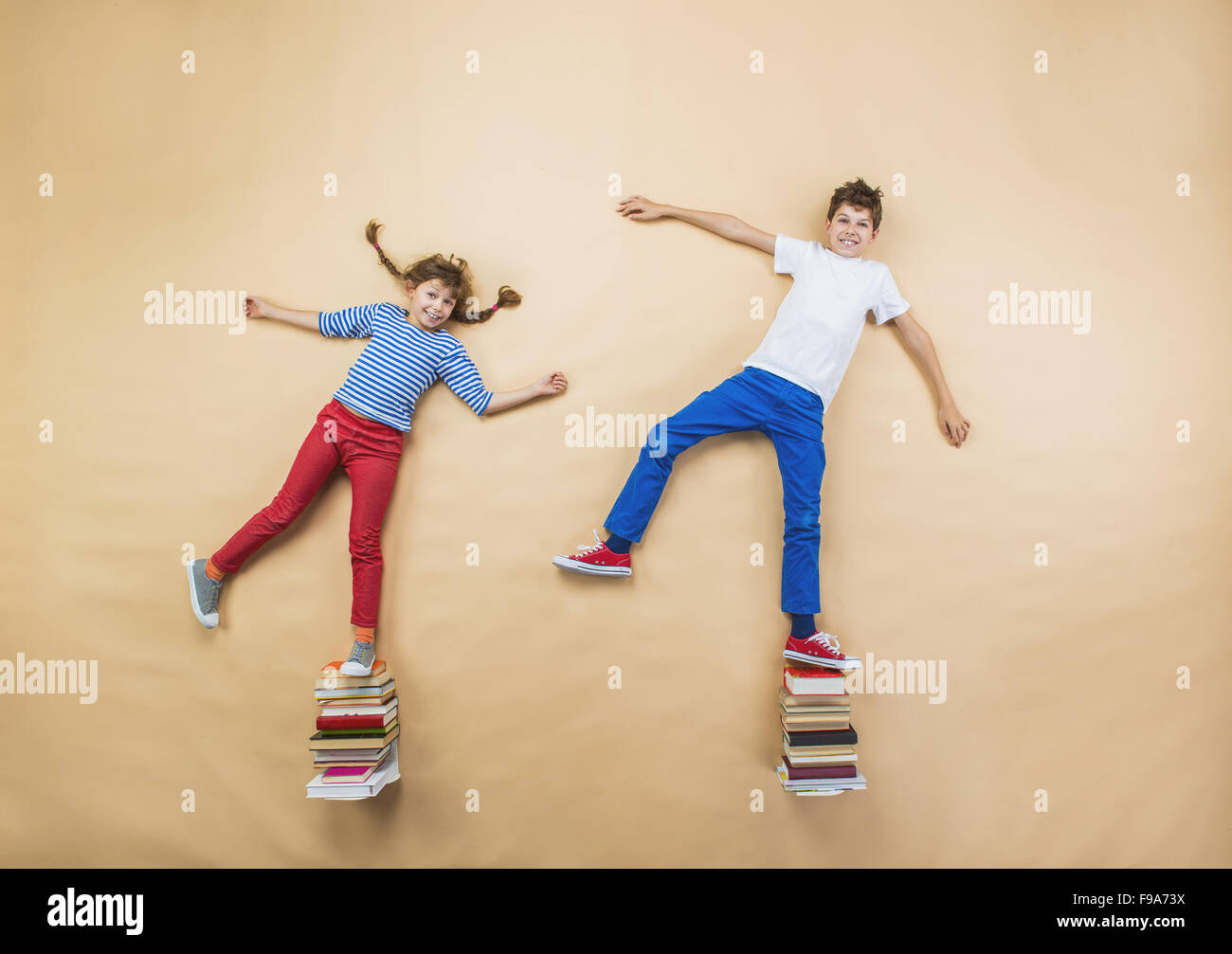 Glückliche Kinder, die spielen mit Gruppe von Büchern im studio Stockfoto