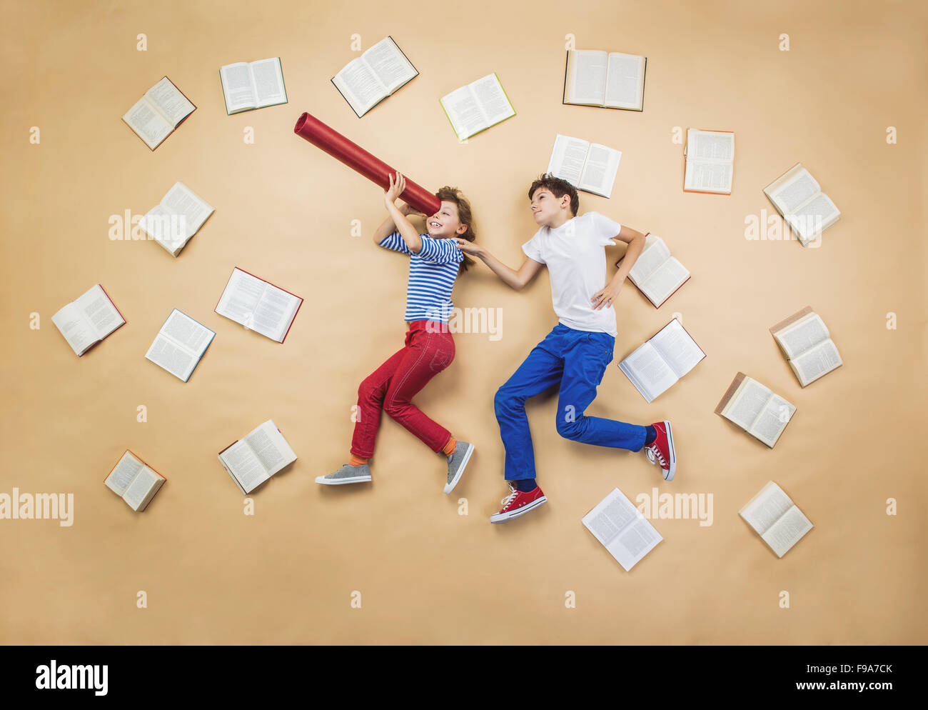 Glückliche Kinder, die spielen mit Gruppe von Büchern im studio Stockfoto